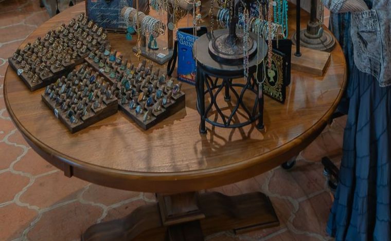 Trays of rings with colorful stones on a round wooden table
